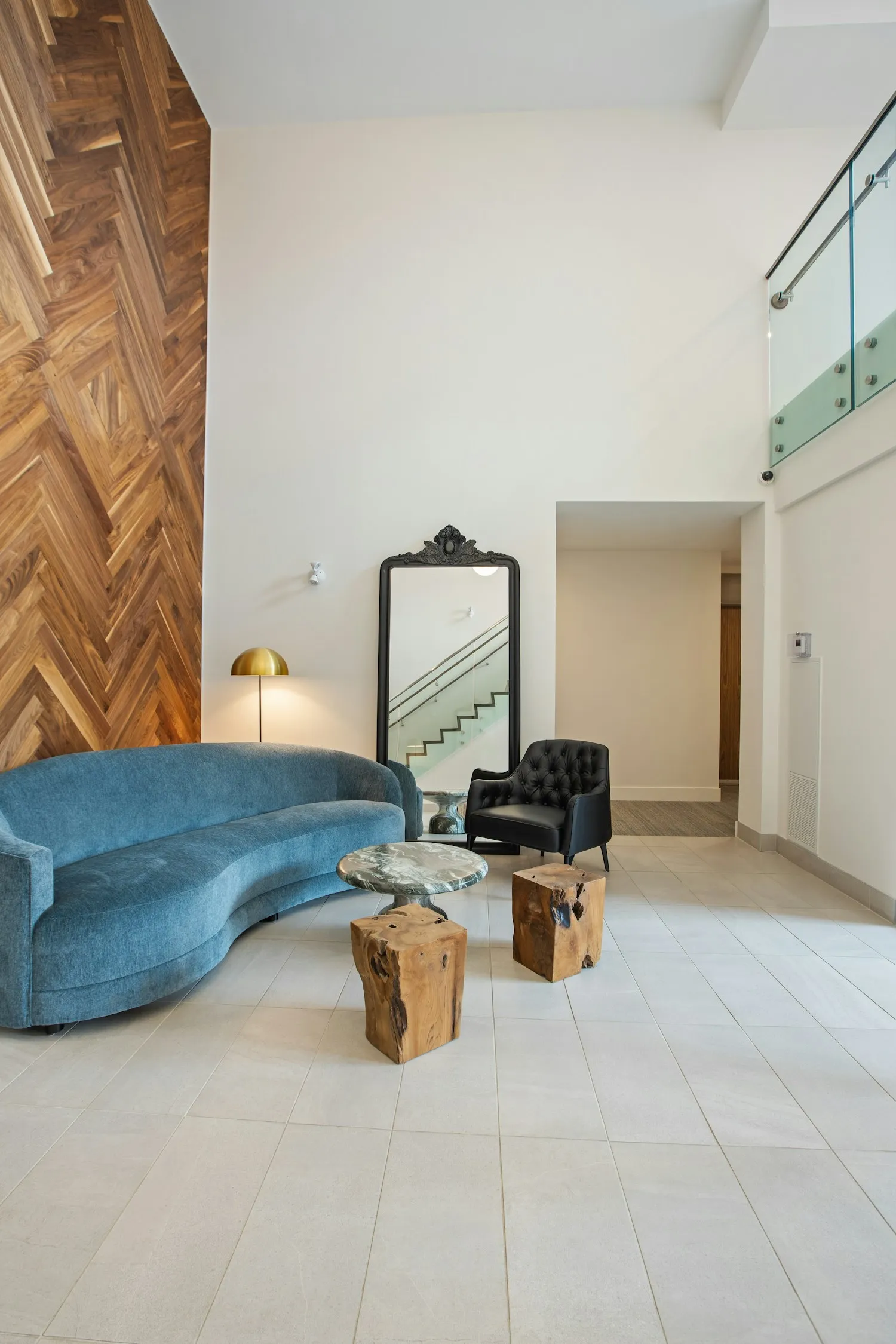 Illustrative shared lobby with blue seating, glass railings and a tiled floor
