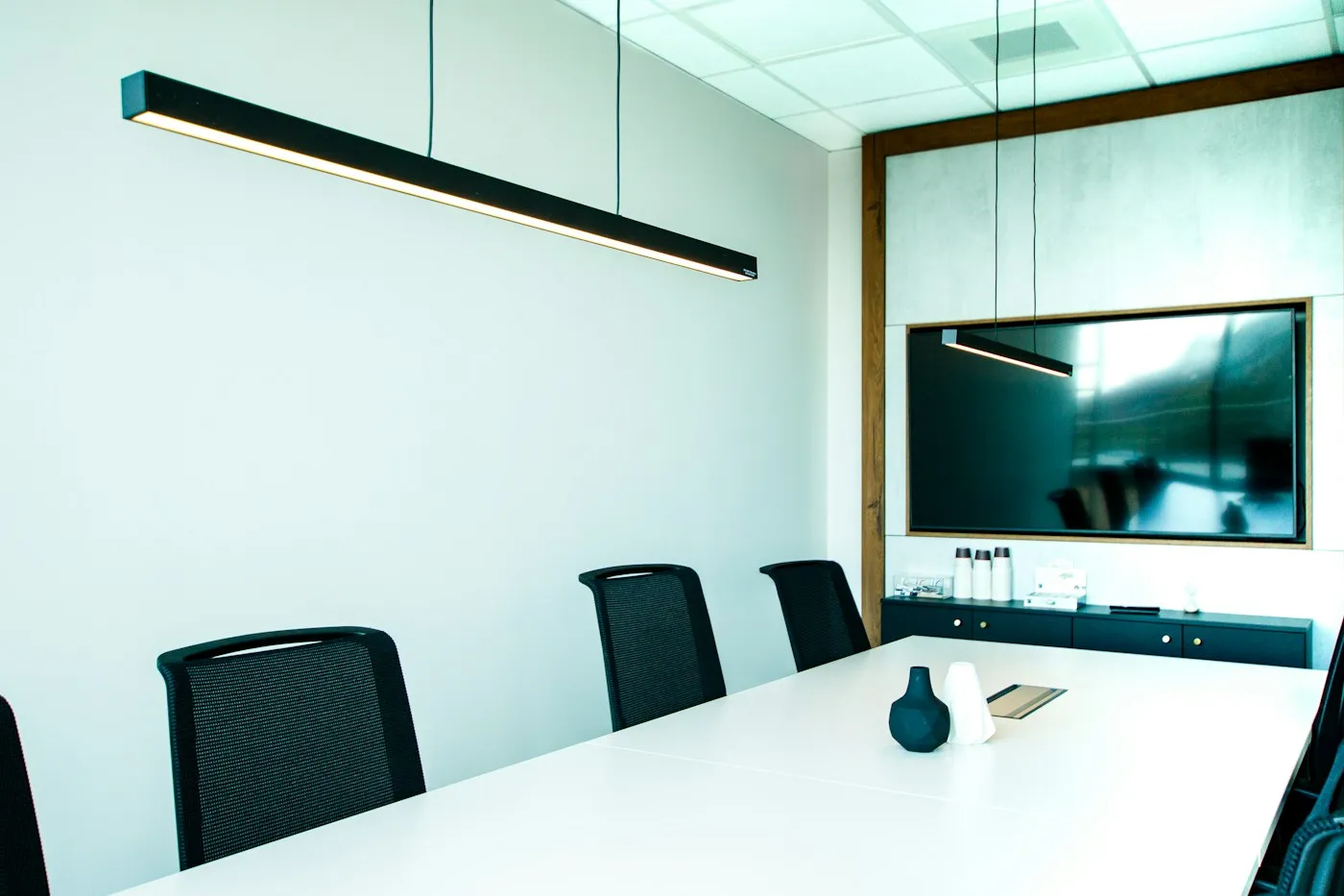 Illustrative meeting room with a white table and black office chairs