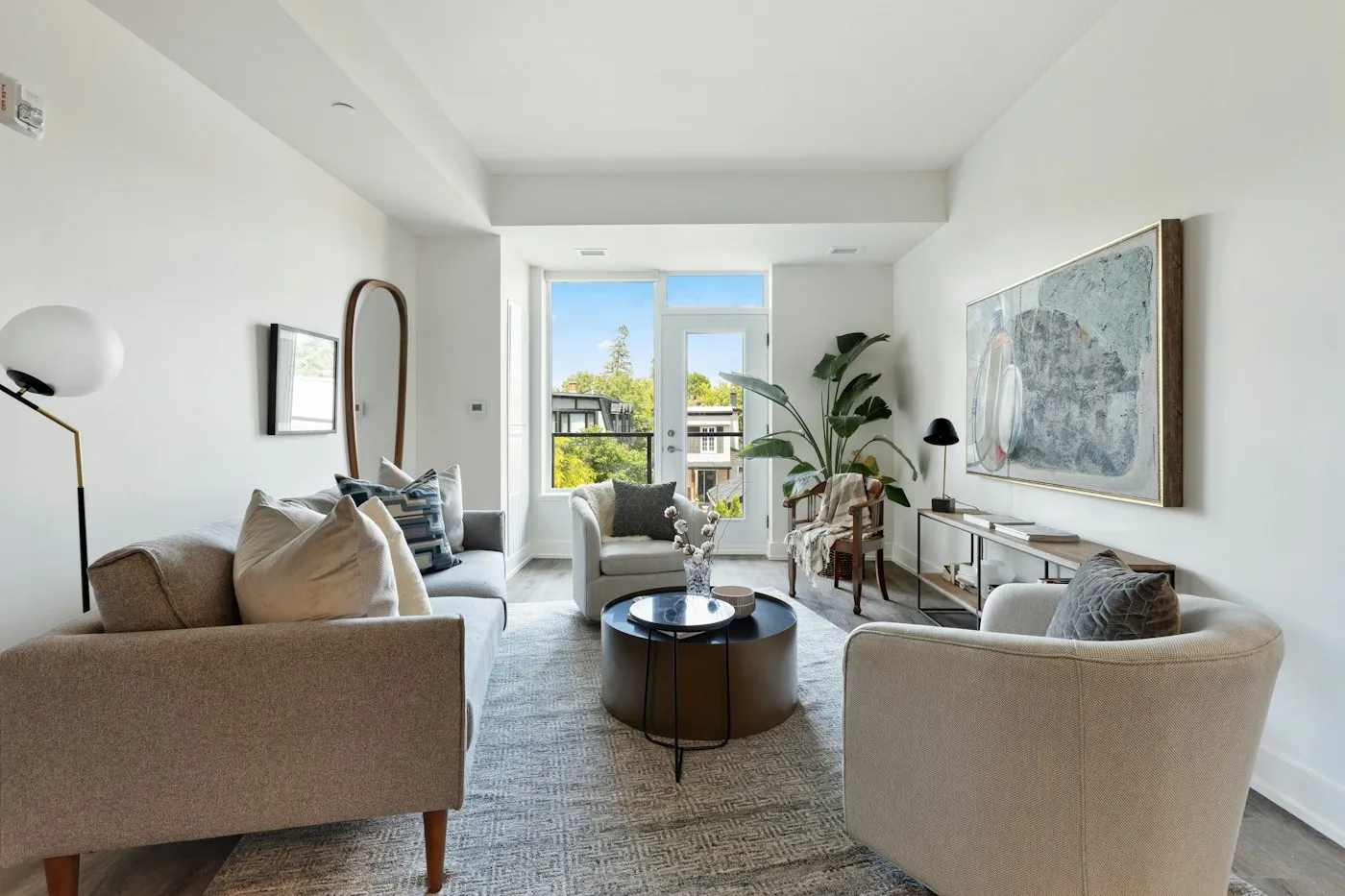 Illustrative living room with soft neutral seating, natural light and a leafy plant